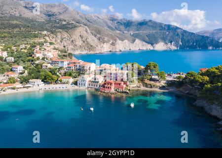 Vista panoramica aerea del pittoresco villaggio di pescatori di Assos, Cefalonia, Grecia. Viaggia in barca a vela ormeggiata sul mare turchese Foto Stock