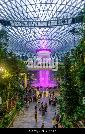 Insside la cupola all'Aeroporto di Chang, Singapore con il treno che passa con un cielo blu. Foto Stock