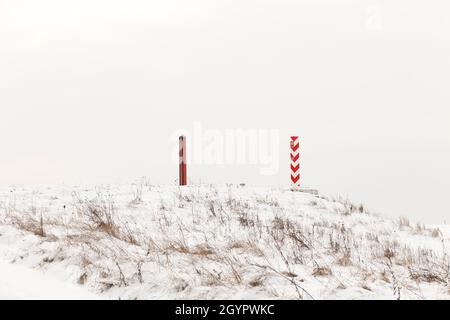 Pilastri di confine di Bielorussia e Polonia al confine in un campo invernale Foto Stock