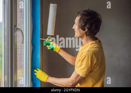 Builder o handyman è impegnato nella riparazione o installazione di finestre Foto Stock