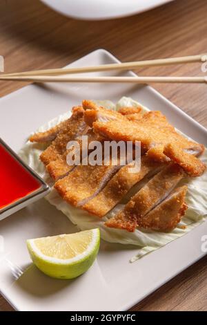 Filetto di pollo pastellato in stile orientale con salsa dolce e salsa, immagine verticale. Foto Stock