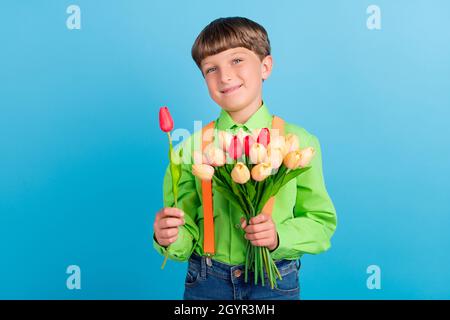 Ritratto di attraente ragazzo di ghepardo nerd che tiene freschi fiori congrats isolato su sfondo di colore turchese teale Foto Stock