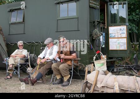 Sheringham, Norfolk, UK - SETTEMBRE 14 2019: Le persone in abiti d'epoca riposano da un esercito cantine durante il week-end 40s Foto Stock