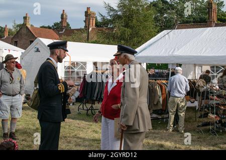 Sheringham, Norfolk, Regno Unito - SETTEMBRE 14 2019: L'uomo in uniforme marina degli anni '40 parla con una coppia anziana in uniformi degli anni '40 durante il weekend degli anni '40 Foto Stock