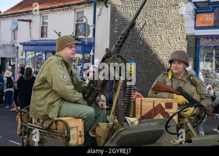 Sheringham, Norfolk, UK - SETTEMBRE 14 2019: Uomini in uniformi militari anni '40 accanto alla mitragliatrice attaccata su una jeep Foto Stock