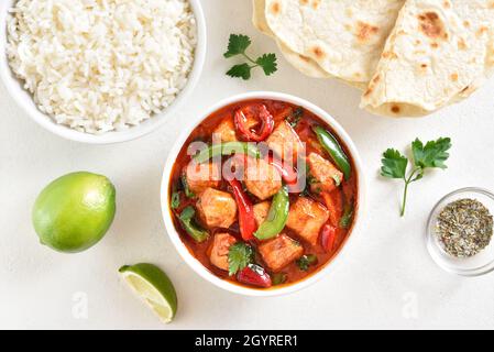 Curry di pollo rosso di stile thailandese con verdure su sfondo di pietra bianca. Vista dall'alto, piatto Foto Stock