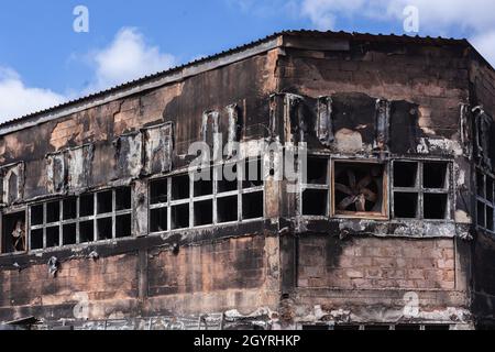 Incendio arson fabbrica magazzino edificio bruciato danneggiato primo piano dettaglio economia business industria disoccupazione atmosfera politica. Foto Stock