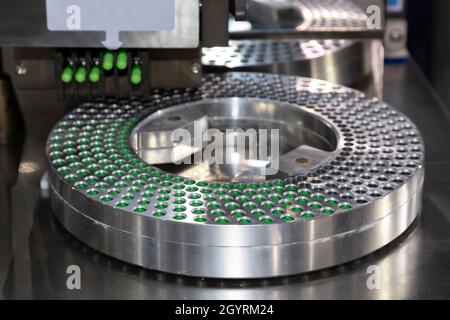 Capsula verde medicina pillola in una linea di produzione di medicina macchina riempitrice a pharmaceutical manufacturing factory. La tecnologia medica e industr Foto Stock