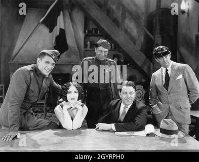 VICTOR McLAGLEN DOLORES DEL RIO EDMUND LOWE playwright LAURENCE STALLINGS e il regista RAOUL WALSH sul set candid durante le riprese di CIÒ CHE IL regista PRICE GLORY 1926 RAOUL WALSH suona Laurence Stallings e Maxwell Anderson Fox Film Corporation Foto Stock