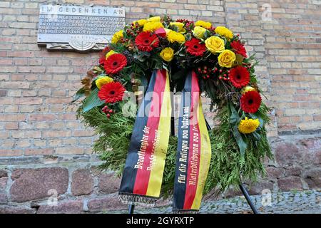 Halle, Germania. 9 ottobre 2021. 09 ottobre 2021, Sassonia-Anhalt, Halle (Saale): Una corona del governo tedesco si trova di fronte alla sinagoga di Halle/Saale in memoria delle vittime dell'attacco di Halle. Due anni dopo l'attacco terroristico di destra alla più alta festa ebraica Yom Kippur a Halle, le vittime sono ricordate. Il 09 ottobre 2019, un estremista di destra pesantemente armato aveva tentato di stordire la sinagoga e causare un massacro tra 52 visitatori. Quando fallì, sparò un passer-by di fronte al luogo di culto e un giovane in un vicino ristorante kebab. Foto: Hendrik Schm Foto Stock