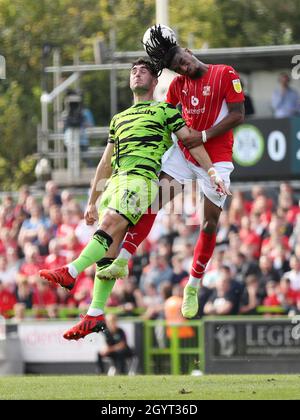 Akinwale Odimayo di Swindon Town e Jordan Moore-Taylor di Forest Green Rovers (a sinistra) combattono per la palla durante la partita della Sky Bet League Two al New Lawn completamente carico, Nailsworth. Data foto: Sabato 9 ottobre 2021. Foto Stock