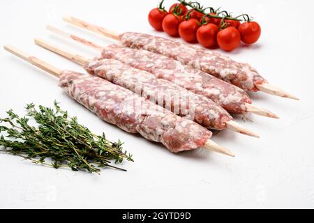 Kebab di carne crudo kofta, con ingredienti alla griglia, su sfondo bianco tavola di pietra Foto Stock