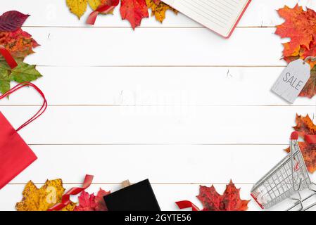 Composizione per acquisti autunnali con borsa, carrello, pendente, gesso e tampone. Spazio libero al centro per la promozione di testo di vendita. Vista dall'alto, appartamento posato composi Foto Stock