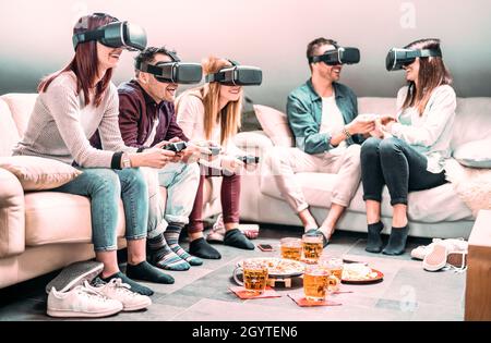 Amici che giocano con il visore vr a casa - realtà virtuale e tecnologia indossabile con le persone che si divertono con i videogiochi 3d - generazione z digitale tre Foto Stock