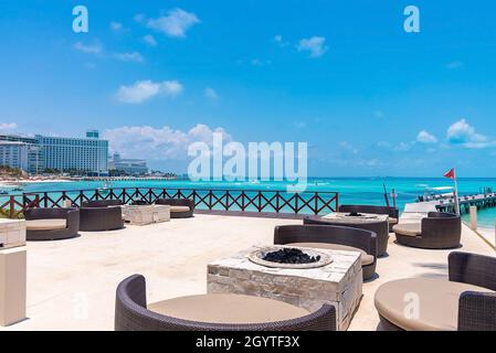 Sedie e tavoli vuoti di ristorante aperto sul molo dal mare Foto Stock