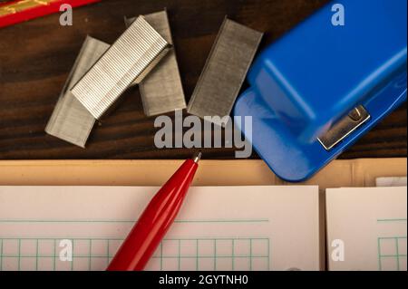 Pinzatrice per ufficio, pinzatrice e carta bianca sul tavolo, primo piano, messa a fuoco selettiva Foto Stock