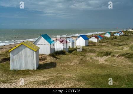Bunte Strandhäuser in den Dünen am Strand von Gouville-sur-Mer, Normandie, Frankreich | MULTICUORED Beach Huts nelle dune di Gouville-sur-Mer BE Foto Stock