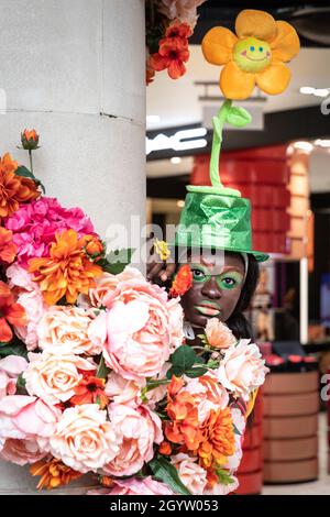 Mayfair, Londra, Regno Unito, 09 ottobre 2021. Il modello Alexandra si pone con un bouquet a Fenwicks, nel suo cappello colorato con girasole. I modelli in abiti e accessori stravaganti si presentano a un flashmob moda del designer Pierre Garroudi nelle strade di Mayfair nel centro di Londra. Foto Stock