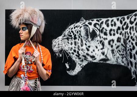 Mayfair, Londra, Regno Unito, 09 ottobre 2021. Il modello Isabella si pone in Bond Street con una grande fotografia del gatto della campagna #MyWestemd. I modelli in abiti e accessori stravaganti si presentano a un flashmob moda del designer Pierre Garroudi nelle strade di Mayfair nel centro di Londra. Foto Stock