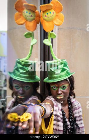 Mayfair, Londra, Regno Unito, 09 ottobre 2021. Il modello Alexandra si pone nel suo cappello colorato con girasole. I modelli in abiti e accessori stravaganti si presentano a un flashmob moda del designer Pierre Garroudi nelle strade di Mayfair nel centro di Londra. Foto Stock