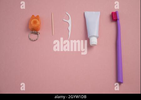 Prodotti per l'igiene orale su fondo rosa. Dentifricio dentifricio e dentifricio. Spazio di copia. Foto Stock