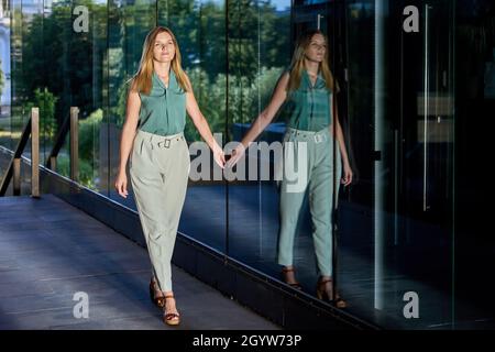 Donna d'affari europea cammina vicino al centro affari durante il giorno. Foto Stock
