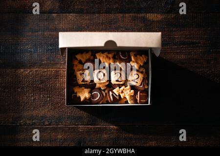 Fai da te biscotti di Natale con 2022 numeri, lettere e forme di albero di Natale in scatola artigianale. Gustosi biscotti di Natale fatti in casa su tavola rustica in legno Foto Stock