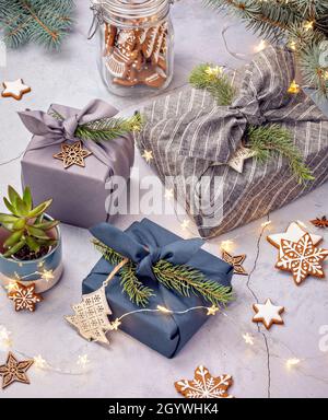 Zero rifiuti di Natale riciclaggio, riutilizzo, stile di vita sostenibile concetto. Confezione regalo ecologica in stile furoshiki e biscotti fatti in casa. Foto Stock
