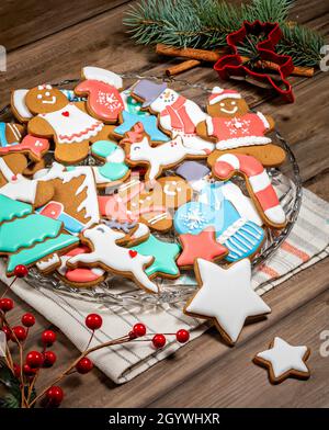 Un vassoio di biscotti di Natale di pan di zenzero, luminosi e colorati, splendidamente decorati. Foto Stock