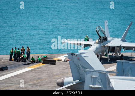 211008-N-RB149-1004 SOUTH CHINA SEA (OTT 8, 2021) i marinai effettuano la manutenzione preventiva sul ponte di volo del vettore aereo di classe Nimitz USS Carl Vinson (CVN 70), 8 ottobre 2021. Carl Vinson Carrier Strike Group è in fase di implementazione nell'area operativa della 7a flotta statunitense per migliorare l'interoperabilità attraverso alleanze e partnership, fungendo da forza di risposta pronta a supportare una regione indopacifica libera e aperta. (STATI UNITI Foto Navy di Mass Communication Specialist terza classe Nicholas carter) Foto Stock