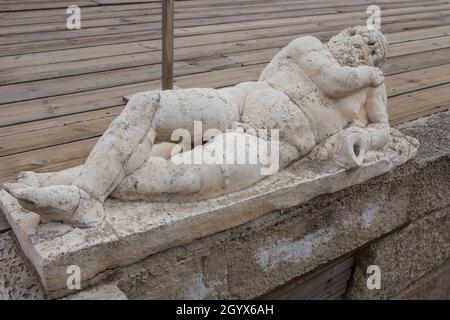 Vecchio che tiene un'anfora. Fontana a forma di statua. Teatro Romano di Medellin, Estremadura, Spagna Foto Stock