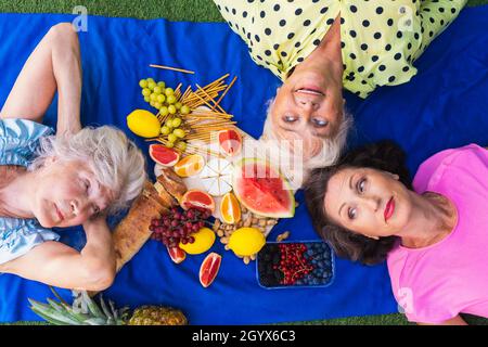 Belle donne anziane rilassarsi a casa nel giardino - tre belle donne mature riposo in un giardino tranquillo cortile Foto Stock
