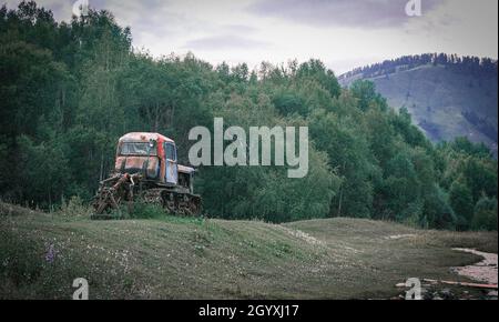 Un vecchio trattore cingolato in paesaggio rurale colorato Foto Stock