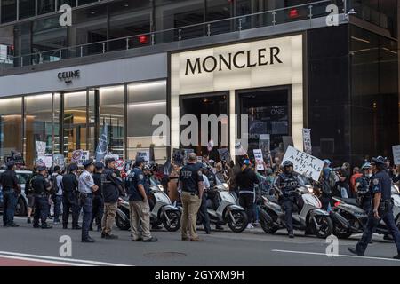 NEW YORK, NY - 9 OTTOBRE: Gli ufficiali della polizia di NYPD osservano la protesta degli attivisti per i diritti degli animali durante una marcia anti-pelliccia di fronte al negozio Moncler su Madison Avenue il 9 ottobre 2021 a New York City. Gli attivisti per i diritti degli animali di Fur Free NYC, una coalizione di organizzazioni senza scopo di lucro che lavorano per vietare la vendita di pellicce a New York City, hanno protestato pacificamente chiedendo ai newyorkesi di sollecitare i loro membri del Consiglio di New York a sostenere il progetto di legge Intro 1476 per la NYC senza pellicce. Foto Stock