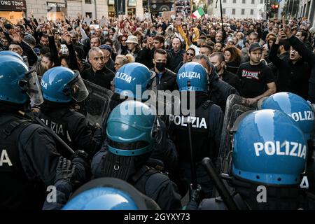 Milano, Italia. 9 ottobre 2021. Le persone si confrontano con gli ufficiali di polizia in marcia sommossa durante una demo No Green Pass per protestare contro l'introduzione delle misure del governo per combattere il covid-19 coronavirus pandemic Credit: Piero Crociatti/Alamy Live News Foto Stock