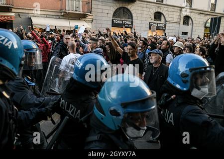 Milano, Italia. 9 ottobre 2021. Le persone si confrontano con gli ufficiali di polizia in marcia sommossa durante una demo No Green Pass per protestare contro l'introduzione delle misure del governo per combattere il covid-19 coronavirus pandemic Credit: Piero Crociatti/Alamy Live News Foto Stock