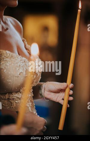 Un fuoco poco profondo di una candela di tenuta di sposa durante una cerimonia nuziale Foto Stock