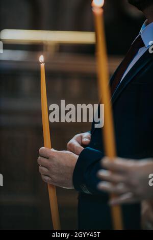 Un fuoco poco profondo di un maschio che tiene la candela durante una cerimonia nuziale Foto Stock