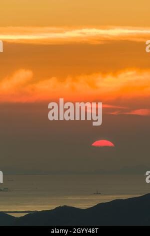 Tramonto sull'isola di Lantau e l'estuario del fiume Pearl visto dal livello 106 dell'ICC a Kowloon occidentale, Hong Kong Foto Stock