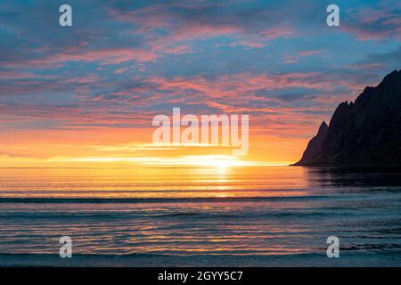 Cielo ardente sul mare artico durante il sole di mezzanotte, Ersfjord, Senja, contea di Troms, Norvegia Foto Stock