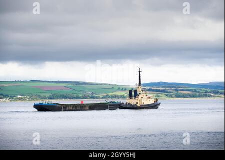 Tugboat trasporto galleggiante container piattaforma in mare Foto Stock