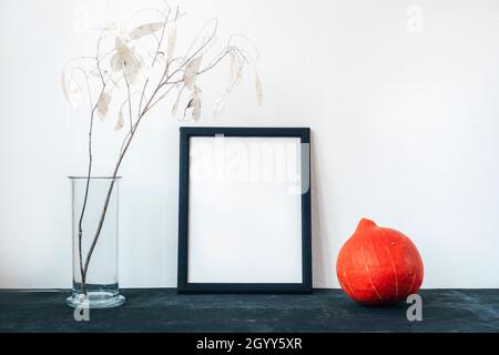 Cornice bianca, zucca hokkaido e lunaria fiori secchi in vaso di vetro. Mockup, spazio di copia. Thanksgiving, Halloween, vacanze d'autunno concetto. Foto Stock