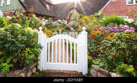 ST PETER-ORDING, GERMANIA - 21 SETTEMBRE 2021: Casa tradizionale frisone con tetto paglia e giardino fiorito, Sankt Peter Ording, Germania Foto Stock