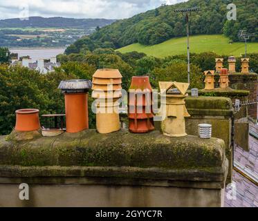 Pentole di camino sul tetto visto dal livello degli occhi sulla passeggiata medievale delle mura della città di Conwy Foto Stock