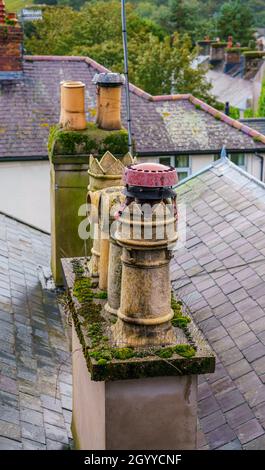 Pentole di camino sul tetto visto dal livello degli occhi sulla passeggiata medievale delle mura della città di Conwy Foto Stock