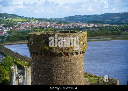 Vista dell'estuario e una torre sul lato nord del ben conservato castello medievale Conwy 13 ° secolo, una fortezza imponente nel Galles del Nord Foto Stock