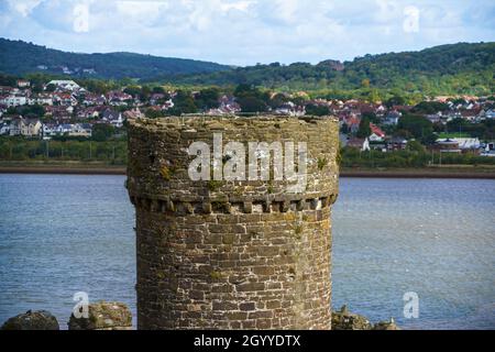 Vista dell'estuario e una torre sul lato nord del ben conservato castello medievale Conwy 13 ° secolo, una fortezza imponente nel Galles del Nord Foto Stock