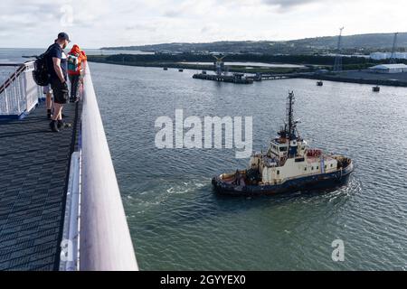 I passeggeri che guardano la nave da rimorchiatore Svitzer Sussex tirano il traghetto MS Stena Edda all'inizio di una traversata diurna da Belfast nell'Irlanda del Nord a Liverpool Foto Stock