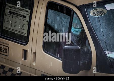 HAVANA, CUBA - 14 settembre 2021: Un colpo di infermiera in un taxi collettivo in attesa di un paziente covid-19 durante la pioggia a l'Avana, Cuba Foto Stock