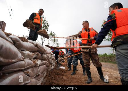 (211010) -- HEJIN, 10 ottobre 2021 (Xinhua) -- i soccorritori fortificano la diga temporanea contro l'alluvione nel villaggio di Lianbo a Hejin City, provincia di Shanxi della Cina settentrionale, 10 ottobre 2021. Più di 120,000 persone sono state evacuate temporaneamente dopo continue deflussi innescati alluvioni nella provincia di Shanxi nella Cina settentrionale, ha detto le autorità Domenica. Le inondazioni hanno sconvolto la vita di 1.76 milioni di residenti provenienti da 76 contee, città e distretti, secondo il dipartimento provinciale di gestione delle emergenze. Circa 190,000 ettari di colture sono stati danneggiati e più di 17,000 case crollate, la departme Foto Stock